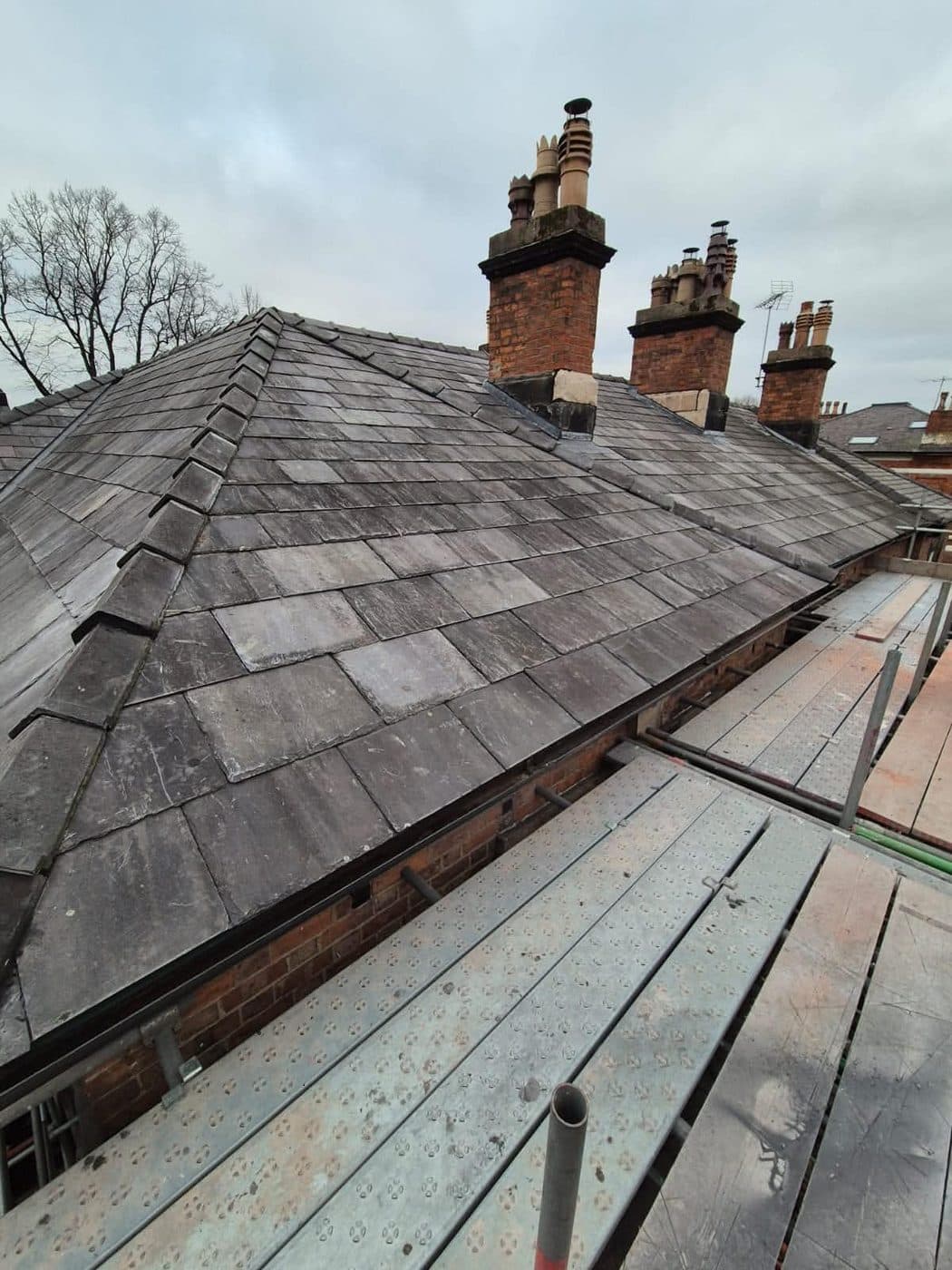 Repaired slate roof with multiple chimney stacks, Oxton