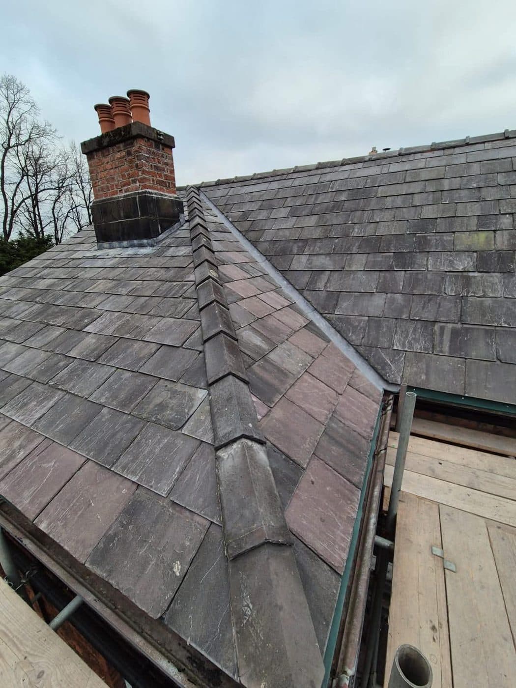Repaired slate roof section blending into the original tiles, Oxton